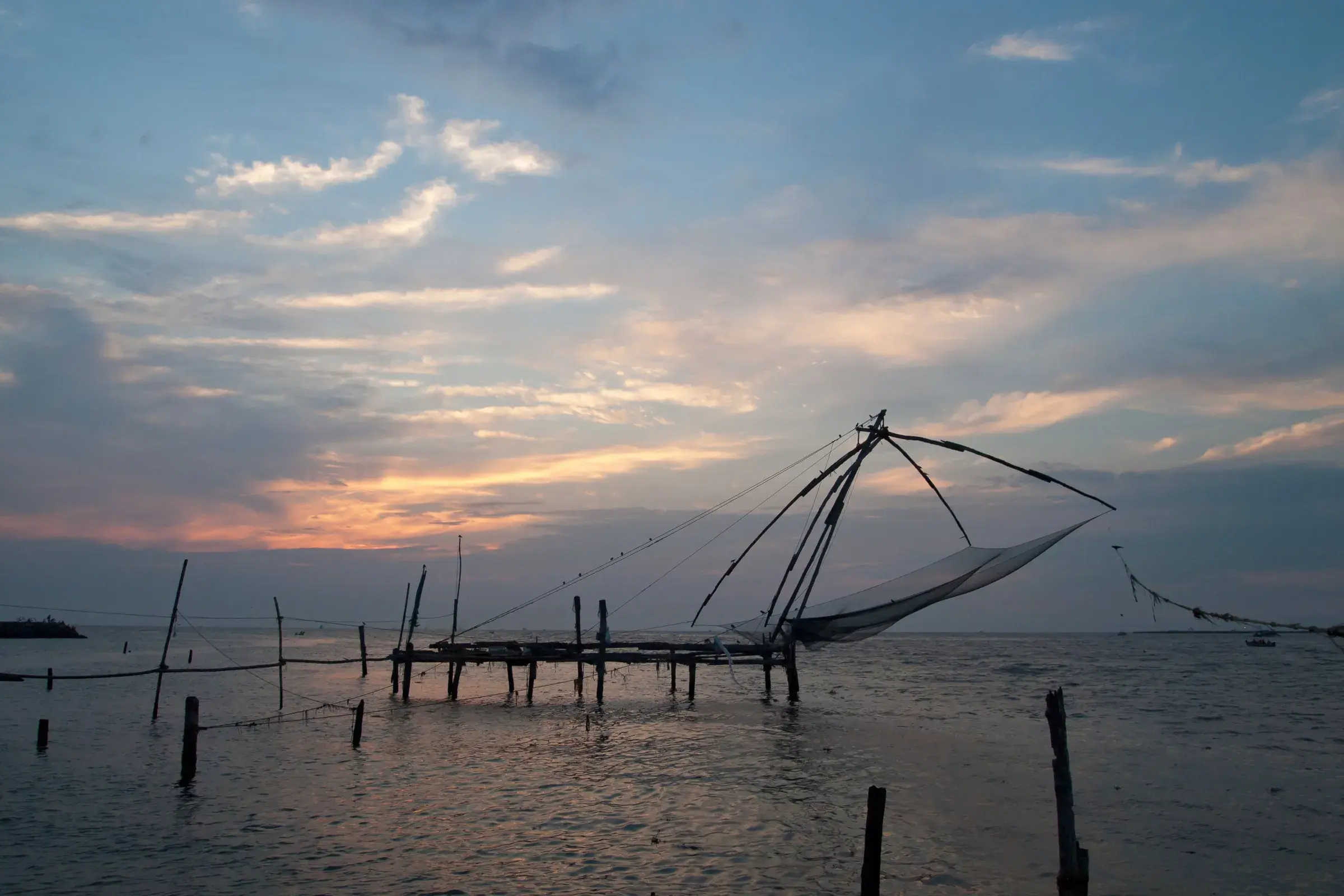Chinese fishing nets silhouetted at sunset on the Fort Kochi waterfront